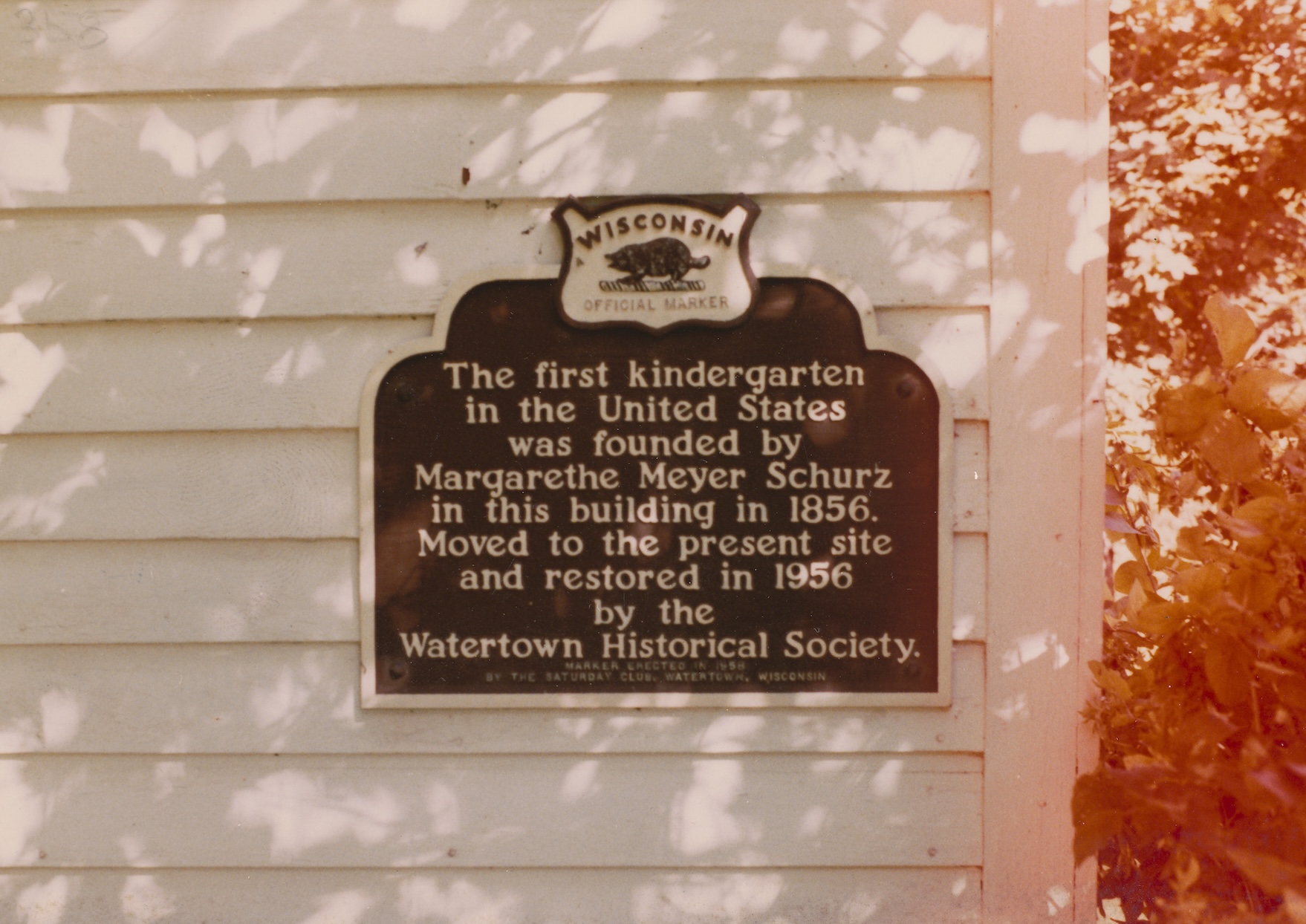 Fotografie des Schildes an dem von Margarethe Meyer Schurz gegründeten ersten Kindergarten in Watertown, Wisconsin (USA). Die Inschrift auf dem Schild lautet: "The first kindergarten in the United States was founded by Margarethe Meyer Schurz in this building in 1856. Moved to the present site and restored in 1956 by the Watertown Historical Society"