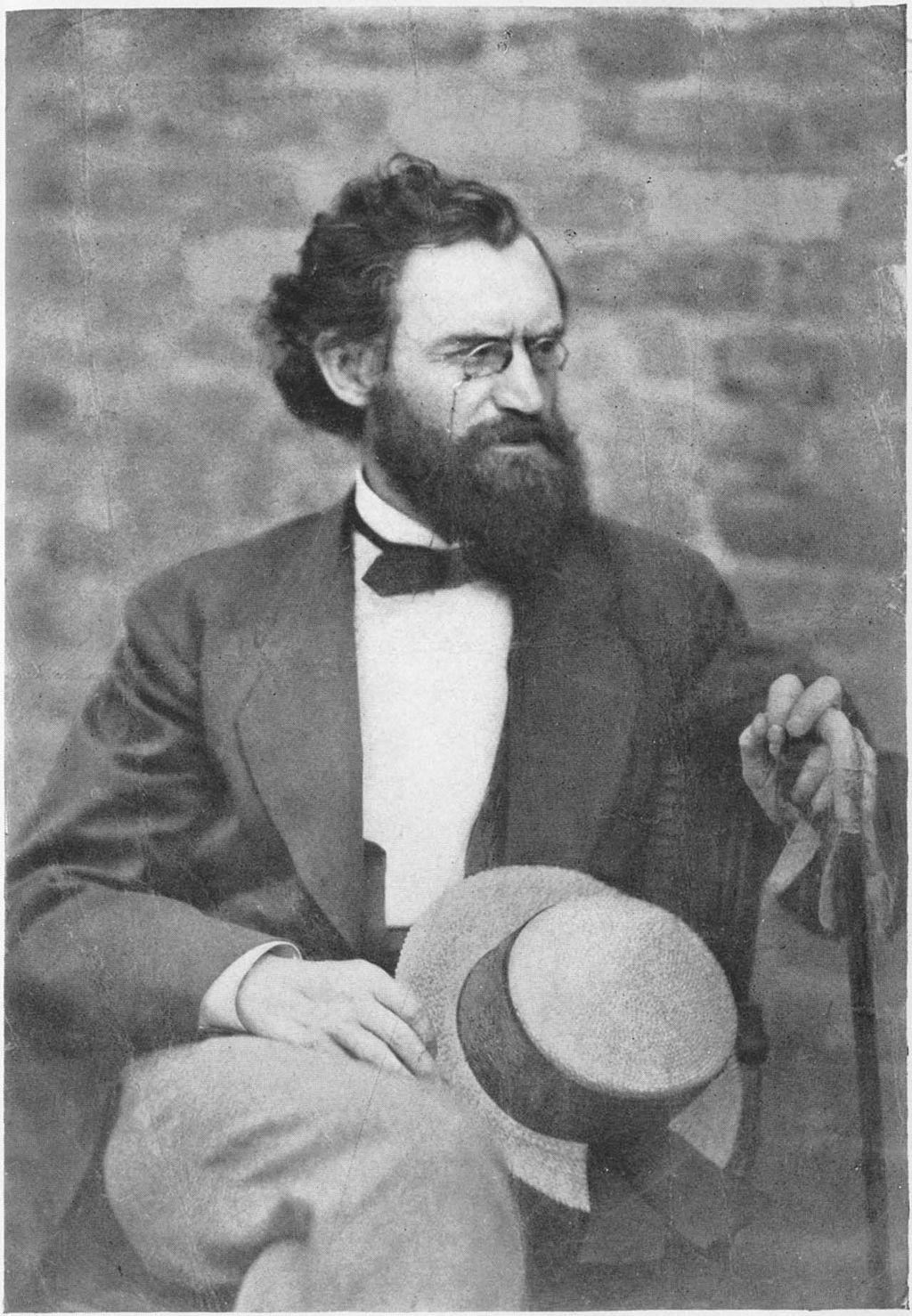 Carl Schurz seated facing a bit to the right holding a straw hat and a cane, 1879.